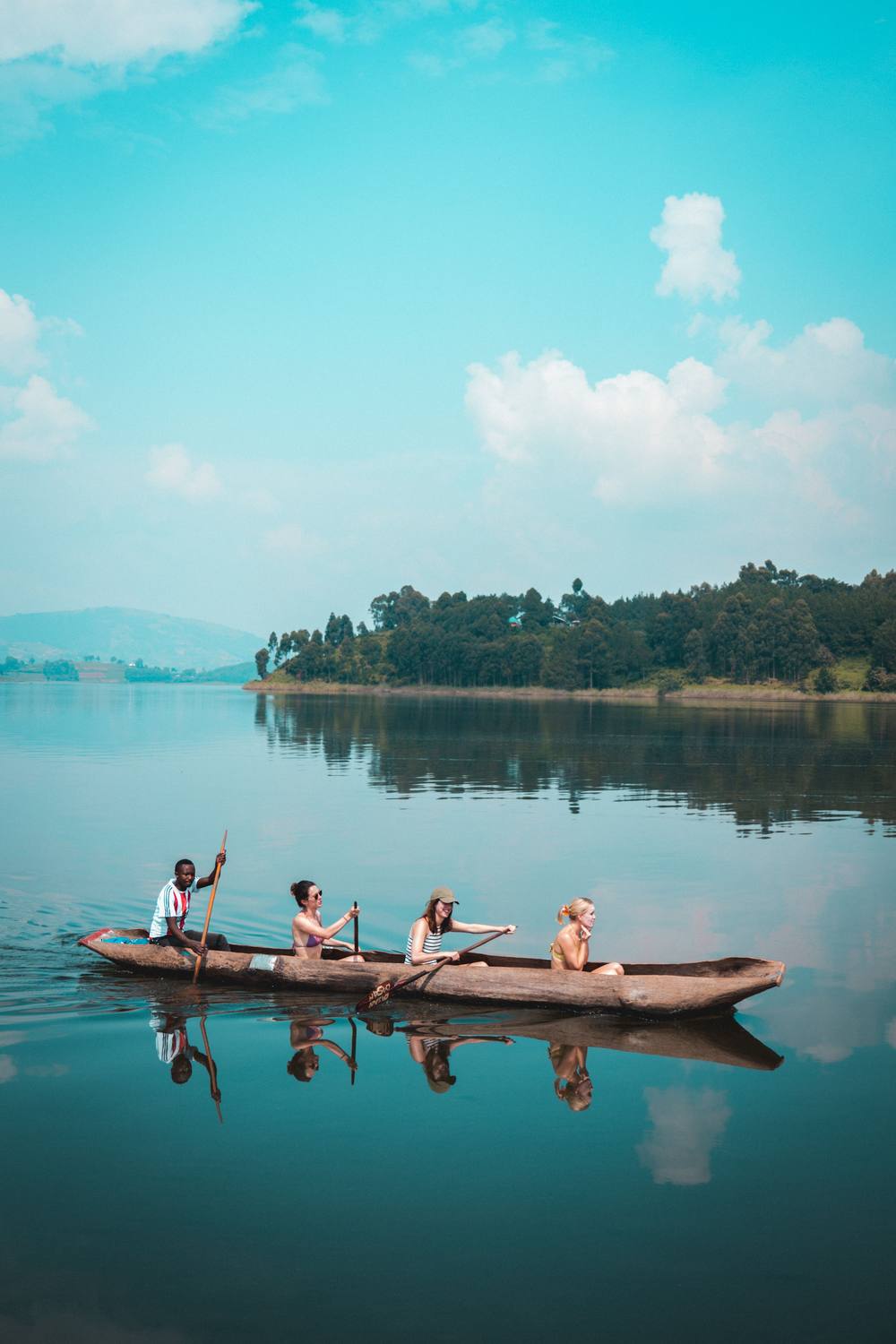 Tourists paddling a dugout canoe on Lake Bunyonyi