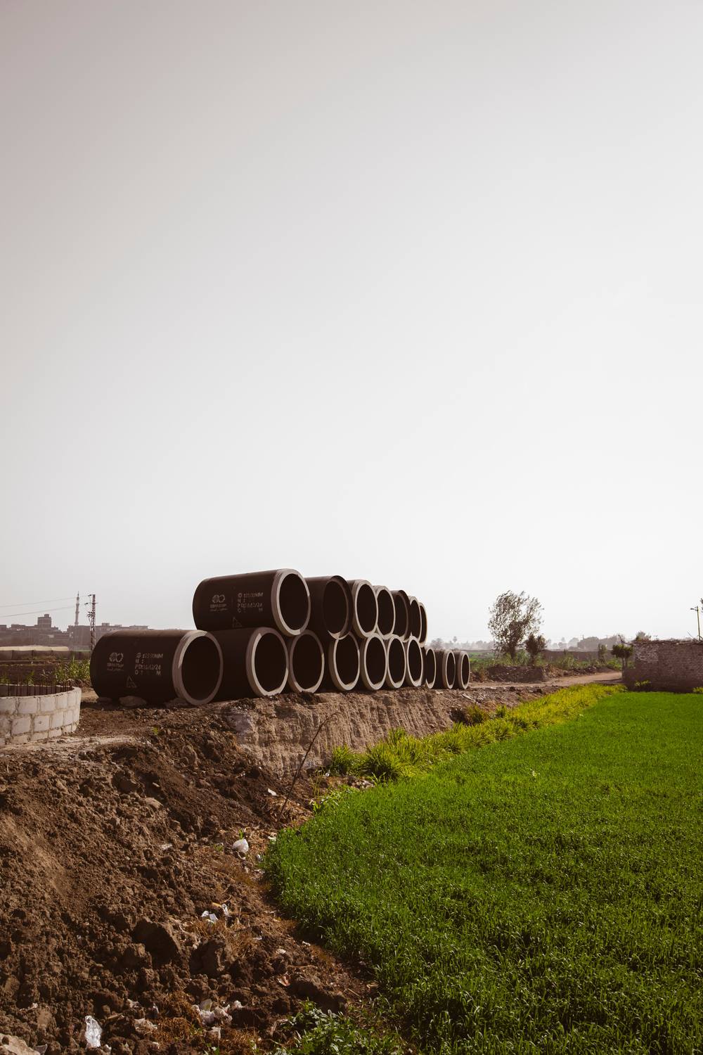 Row of precast concrete culvert pipes beside a road